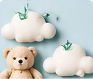 A plush teddy bear and white clouds on a pastel blue background.
